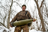 Ukrajinský voják nese 155mm dělostřelecký granát (archivní foto)