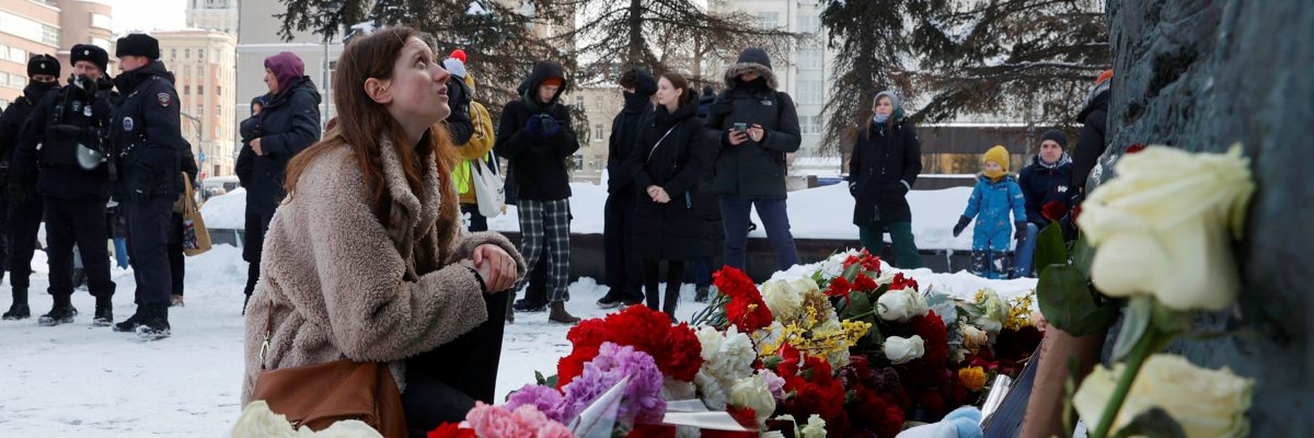 Žena sedí u Solověckého kamene, který slouží jako památník obětem politických represí. Právě tam se lidé shromáždili, aby uctili památku ruského opozičního vůdce Alexeje Navalného