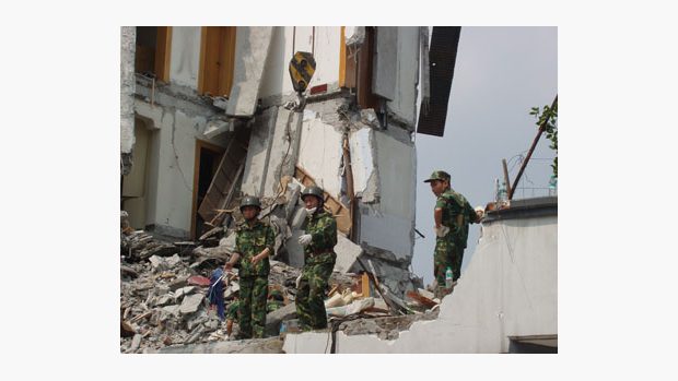 Čínští vojáci odklízejí ruiny domů