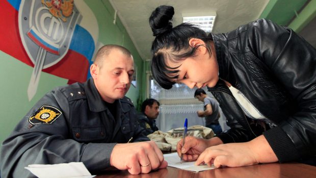 Zadržená migrantka ze Střední Asie v Rusku, který podepisuje dokumenty k deportaci