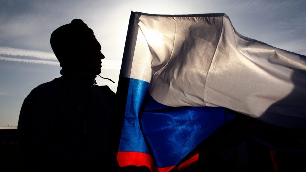 Divák s ruskou vlajkou při příchodu na závěrečný ceremoniál zimních olympijských her 2014 v Soči