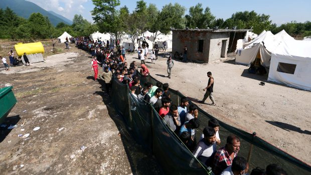 Běženci v uprchlickém táboře Vučjak na severozápadě Bosny čekají ve frontě na jídlo a oblečení