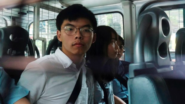 Prodemokratičtí aktivisté Joshua Wong a Agnes Chow přijíždějí v policejní dodávce v roce 2019 (archivní foto)