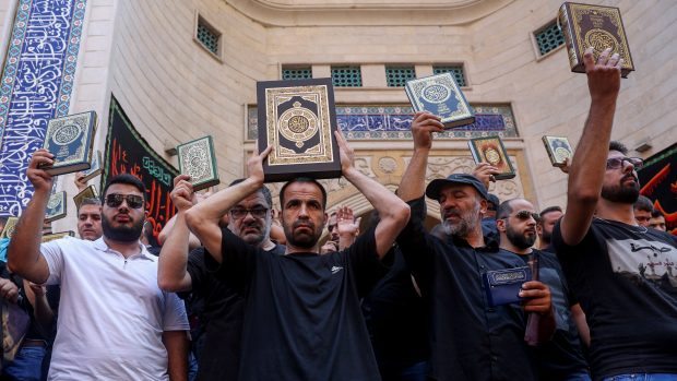 Muslimové v Libanonu stojí s výtisky Koránu před mešitou, aby odsoudili ničení Koránu ve Švédsku