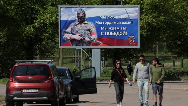 Lidé ve městě Vyborg v Leningradské oblasti procházejí kolem billboardu, na kterém je napsáno: „Milujeme vás! Jsme na vás hrdí! Čekáme na vás s vítězstvím!“ (archivní foto)