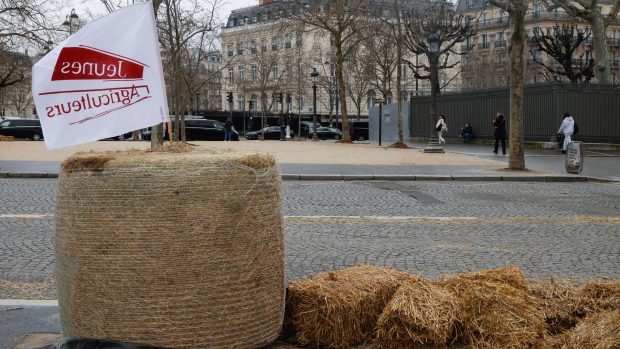 Sláma leží na chodníku v den protestu zemědělců proti cenovým tlakům, daním a ekologickým regulacím, které sdílejí zemědělci v celé Evropě, v Paříži