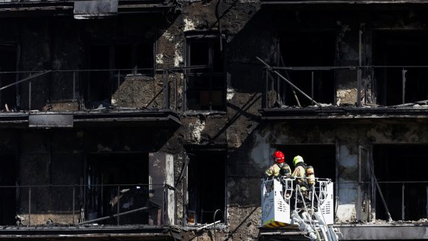 Španělští hasiči pracují na vyklízení vyhořelého domu ve Valencii
