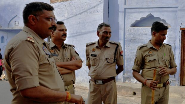 Policisté stojí na stráži před volební místností během třetí fáze parlamentních voleb v okrese Sambhal na severu indického státu Uttarpradéš