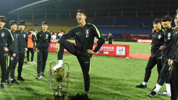 Inkriminovaný moment. Jihokorejský fotbalista slaví s nohou na poháru