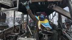 Ukrajina, Kyjev. Proevropský demonstrant ve shořelých troskách policejního autobusu