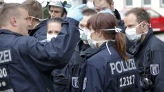 Němečtí policisté v ochranných maskách v berlínské čtvrti Pankow