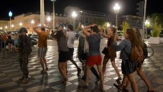 Lidé s rukama nad hlavou procházejí místem v Nice, které po útoku uzavřela armáda
