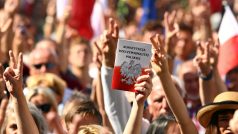Lidí držící výtisk ústavy na demonstraci proti zásahům vládní strany Právo a spravedlnost do polského nejvyššího soudu.