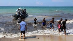 Migranti opouští záchranářskou loď na pobřeží u Tripolisu (19.6.2018)