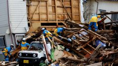 Příslušníci polici pracující v troskách spadlého domu po zemětřesení ve městě Wadžima