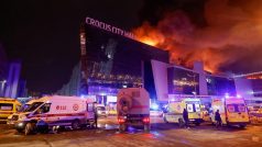 Vozidla ruských záchranných složek parkují u hořící koncertní haly Crocus City Hall po nahlášené střelbě, u Moskvy, Rusko, 22. března 2024