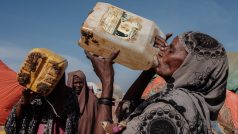 Šedesátiletá žena pije v somálském městě Baidoa vodu ze špinavého barelu
