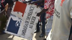 Demonstranti drží nápis stržený z francouzského velvyslanectví v Niamey (Niger) během demonstrace na podporu nigerské junty