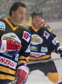 Jiří Bubla (v pozadí) za hercem Martinem Dejdarem (vpředu) při hokejové rozlučce Roberta Reichla a svého syna Jiřího Šlégra.