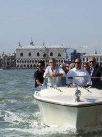 Americký herec Georgie Clooney přijíždí na motorovém člunu do festivalového centra