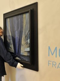 Pracovník galerie Ctirad Janečka kontroluje umístění obrazu Františka Kupky Tvar modré