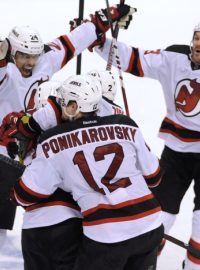 New Jersey Devils center Adam Henrique (hidden) is mobbed by teammates after scoring the game-winning goal against the Florida Panthers in double overtime during Game 7 of their NHL Eastern Conference quarter-final playoff hockey game