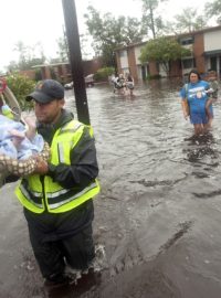 Policista odnáší téměř dvouleté dítě během evakuace před hurikánem Isaac v louisianském Slidellu