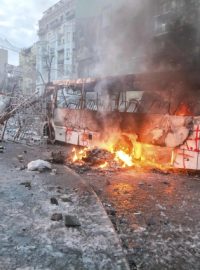 Ukrajina, Kyjev. Muž kouří nedaleko trosek policejního autobusu