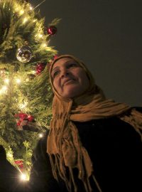 Muslimská žena zapaluje svíčku u vánočního stromu v Káhiře (archivní foto)