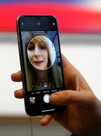 Žena si na modelu telefonu iPhone X nastavuje funkci rozpoznávání obličeje