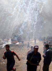 Palestinci v Pásmu Gazy prchají před slzným plynem.