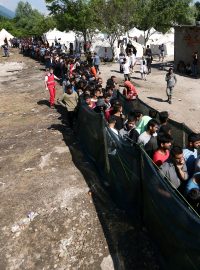 Běženci v uprchlickém táboře Vučjak na severozápadě Bosny čekají ve frontě na jídlo a oblečení