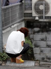 Lidé truchlí před budovou Kyoto Animation, která se stala terčem útoku žháře