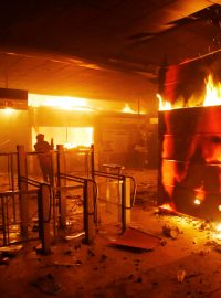 Na jedné ze stanic metra v Santiagu de Chile hoří během demonstrací prodejna lístků