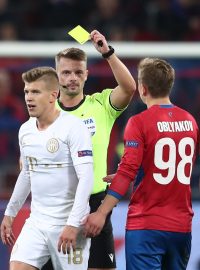 Rozhodčí Pavel Orel uděluje žlutou kartu v utkání CSKA Moskva - Ferencváros