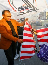 Iráčané v protestu proti náletům pálí před centrálou skupiny Katáib Hizballáh ve městě Najaf americkou vlajku