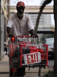 Muž bez domova chodí s nápisem „Exit“ poté, co americké úřady doporučily distancování jako opatření před šířením koronaviru.