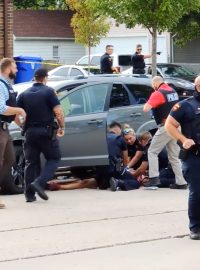 Jacob Blake na zemi u svého auto poté, co ho policisté postřelili sedmkrát do zad