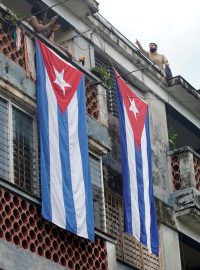 Muž v Havaně zakrývá kubánskými vlajkami dům, ve kterém žije jeden z opozičních lídrů