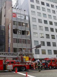 Hasiči před budovou v japonské Ósace, při jejímž požáru zemřelo 27 lidí