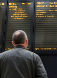 Pasažér dívající se na odjezdovou tabuli v den stávek železničních odborů ve Velké Británii.
