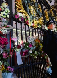 Lidé přinášejí květiny, které kladou na brány Buckinghamského paláce, který je je oficiálním sídlem britského panovníka