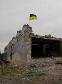 Ukrajinská vlajka na zničené budově po bojích na Ukrajině