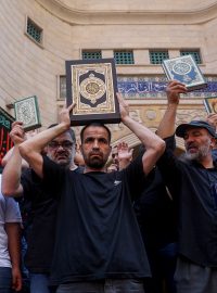 Muslimové v Libanonu stojí s výtisky Koránu před mešitou, aby odsoudili ničení Koránu ve Švédsku