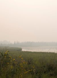 Nad jezerem u města Yellowknife se vznáší kouř z nedalekého požáru