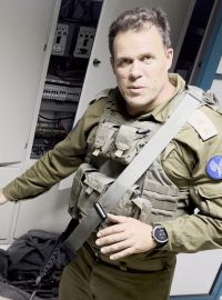 Izraelský voják ukazuje na zbraně, které se podle armnády nacházely v nemocnici Šífa