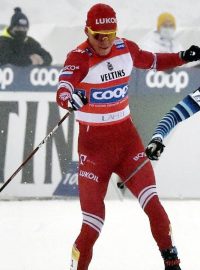 Alexandr Bolšunov (vlevo) v cílové rovince trefuje hůlkou Fina Mäkiho.