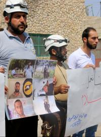 Demonstranti v syrském Idlíbu drží cedule s portréty sedmi členů Bilých přileb, které zastřelili neznámí útočníci. Maskovaní ozbrojenci pak zmizeli s vysílačkami a dalším zabaveným vybavením svých obětí. 13. srpna 2017.