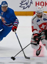 Český hokejista Ondřej Kaše a Christoph Bertschy ze Švýcarska ve vzájemném souboji